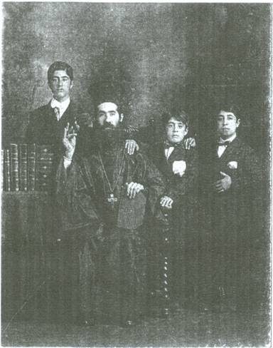 Father Nicola Yanney seated, with his three sons standing around him